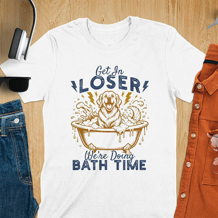 Golden Retriever sitting in a bathtub with soap bubbles and lightning bolts, with the text Get In Loser We're Doing Bath Time on a white t-shirt
