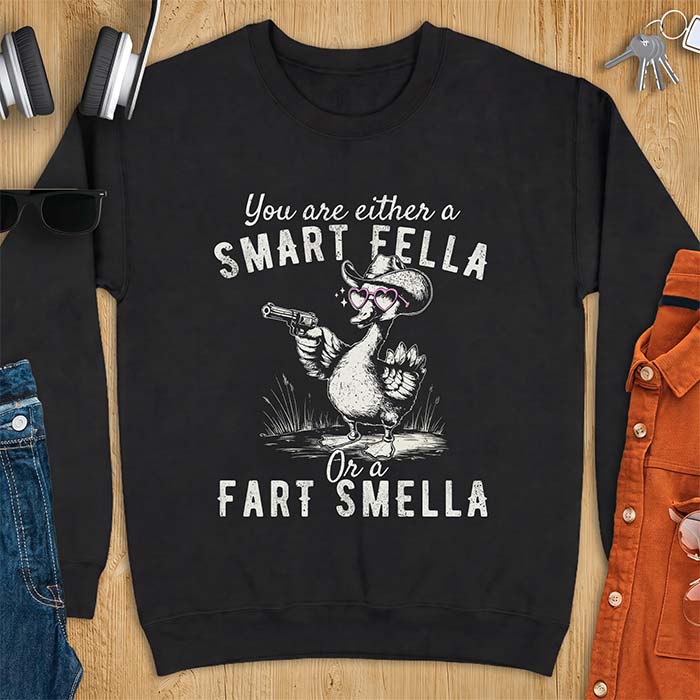 Black sweatshirt with a cowboy goose illustration wearing a hat and pink heart shaped sunglasses, holding a revolver, and the text You Are Either A Smart Fella Or A Fart Smella