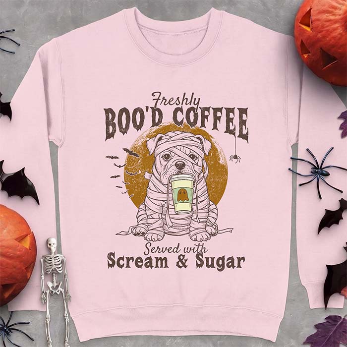 Light Pink sweatshirt with a Halloween graphic of a bulldog wrapped as a mummy holding a coffee cup, bats and a spider under a moon and the text Freshly Boo'd Coffee served with scream & sugar