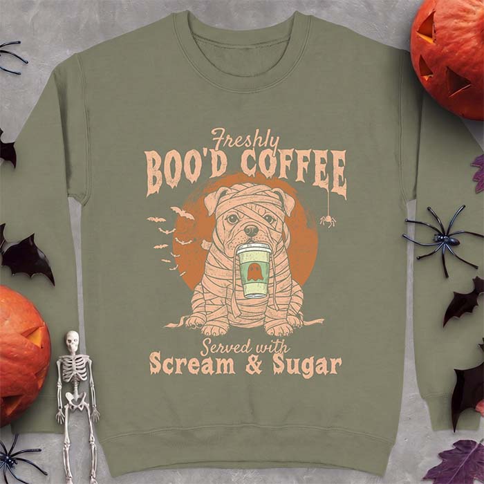 Military Green sweatshirt with a Halloween graphic of a bulldog wrapped as a mummy holding a coffee cup, bats and a spider under a moon and the text Freshly Boo'd Coffee served with scream & sugar