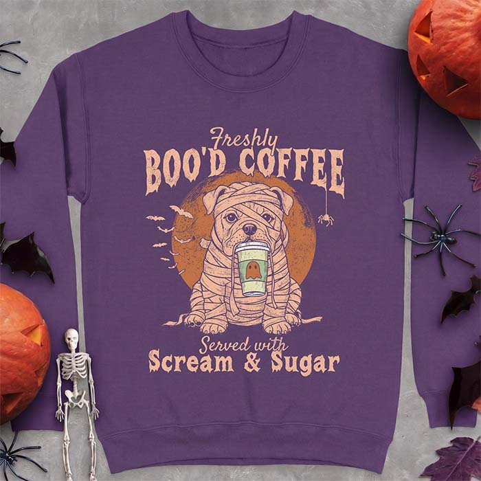 Purple sweatshirt with a Halloween graphic of a bulldog wrapped as a mummy holding a coffee cup, bats and a spider under a moon and the text Freshly Boo'd Coffee served with scream & sugar