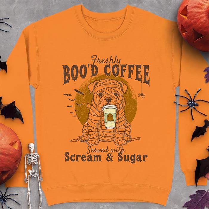 Safety Orange sweatshirt with a Halloween graphic of a bulldog wrapped as a mummy holding a coffee cup, bats and a spider under a moon and the text Freshly Boo'd Coffee served with scream & sugar