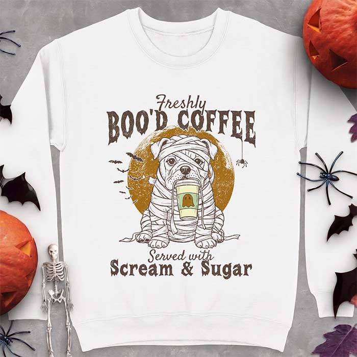 White sweatshirt with a Halloween graphic of a bulldog wrapped as a mummy holding a coffee cup, bats and a spider under a moon and the text Freshly Boo'd Coffee served with scream & sugar