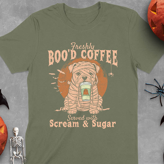 Military Green t-shirt featuring a mummy-wrapped bulldog holding a coffee cup with text 'Freshly BOO'D COFFEE Served with Scream & Sugar' with bats flying in background, full moon behind the bulldog, and a spider hanging from the coffee text