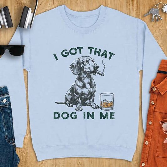 Light Blue sweatshirt with a graphic of a dachshund sitting with a cigar in its mouth and a glass of whiskey beside it and the text I Got That Dog In Me