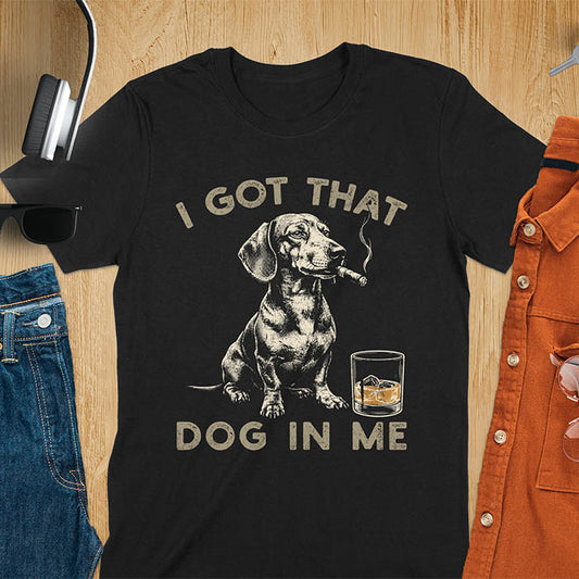Black t-shirt with a vintage graphic of a dachshund smoking a cigar next to a whisky glass, with the text I Got That Dog In Me