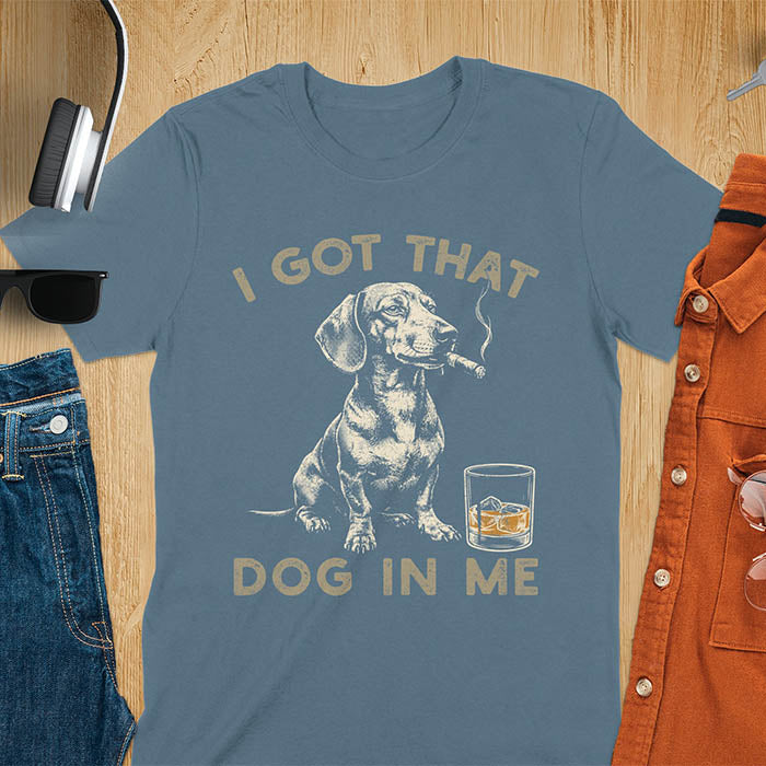 Indigo blue t-shirt with a vintage graphic of a dachshund smoking a cigar next to a whisky glass, with the text I Got That Dog In Me
