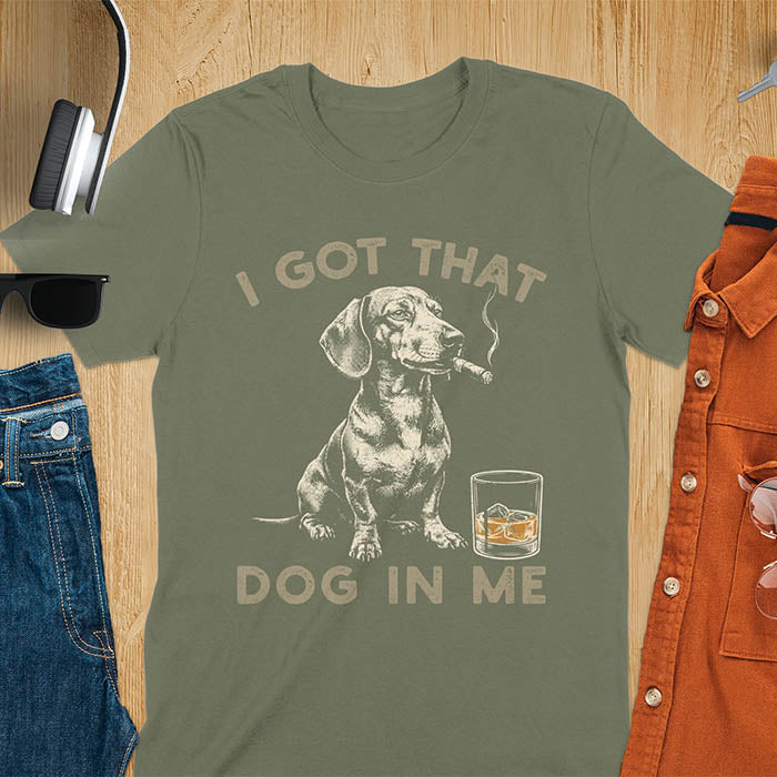 Military green t-shirt with a vintage graphic of a dachshund smoking a cigar next to a whisky glass, with the text I Got That Dog In Me
