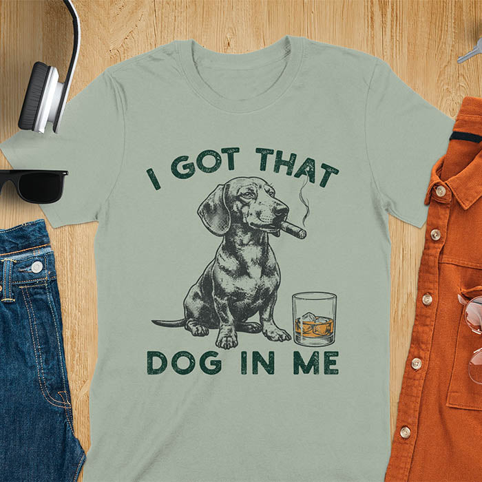 Sage t-shirt with a vintage graphic of a dachshund smoking a cigar next to a whisky glass, with the text I Got That Dog In Me