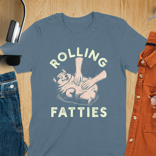 Chubby corgi illustration enjoying tummy rubs with Rolling Fatties text in textured lettering on indigo blue tee