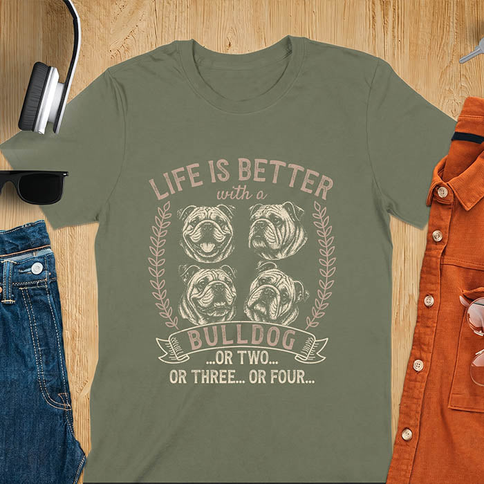 Military green unisex t-shirt with distressed vintage graphic featuring four Bulldog portrait illustrations in a two-by-two grid framed by laurel branches, text reads Life Is Better with a Bulldog or two or three or four