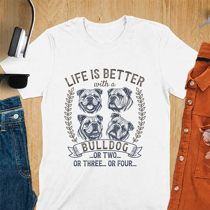 White unisex t-shirt with distressed vintage graphic featuring four Bulldog portrait illustrations in a two-by-two grid framed by laurel branches, text reads Life Is Better with a Bulldog or two or three or four