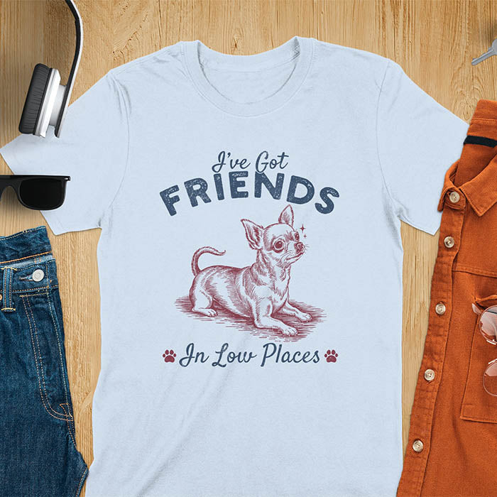 Light blue t-shirt featuring a sitting chihuahua illustration with large ears and paw prints, text reads I've Got Friends In Low Places