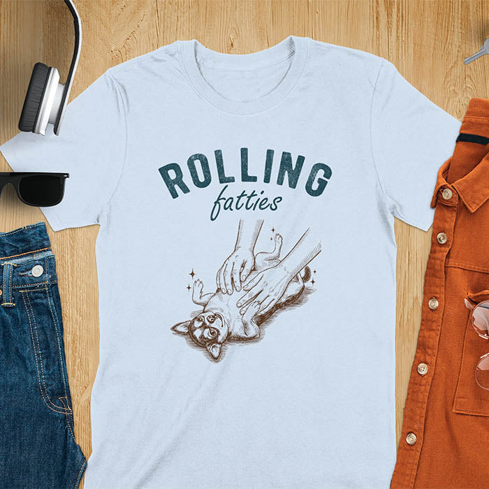 Light blue t-shirt featuring chubby chihuahua lying on back getting belly rubs from a pair of hands, text reads Rolling Fatties