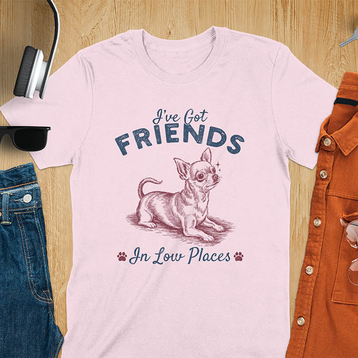 Light pink t-shirt featuring a sitting chihuahua illustration with large ears and paw prints, text reads I've Got Friends In Low Places