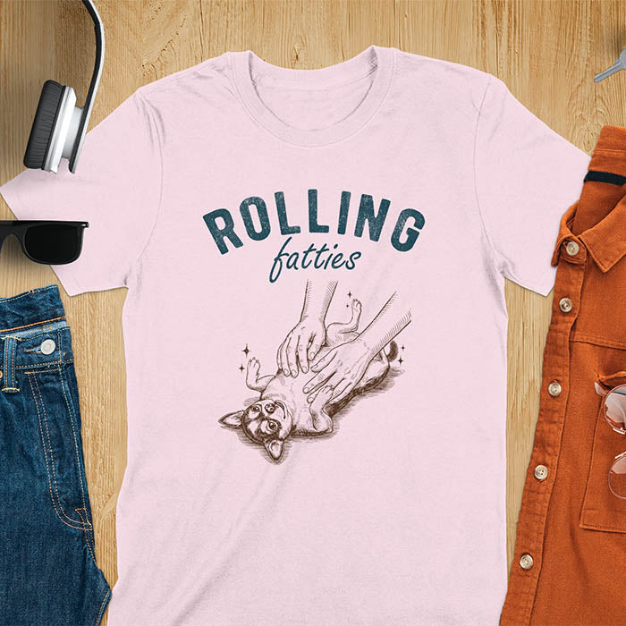 Light pink t-shirt featuring chubby chihuahua lying on back getting belly rubs from a pair of hands, text reads Rolling Fatties