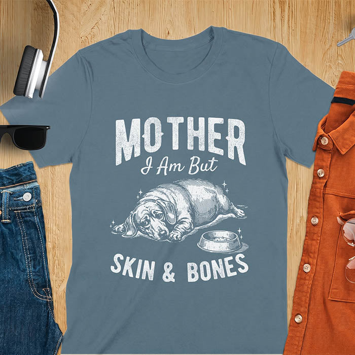 Indigo blue graphic tee with vintage sketch of a chonky sausage dog lying next to an empty bowl, text reads Mother I Am But Skin And Bones