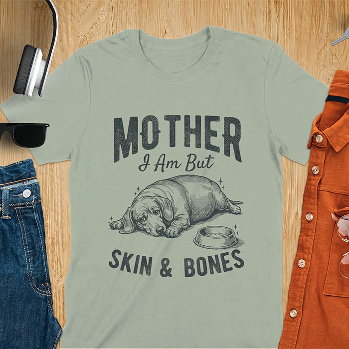 Sage Green graphic tee with vintage sketch of a chonky sausage dog lying next to an empty bowl, text reads Mother I Am But Skin And Bones