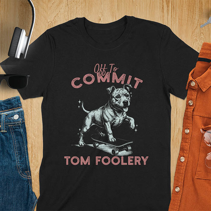 Black t-shirt featuring a pitbull riding a skateboard with text Off To Commit Tom Foolery in vintage red lettering