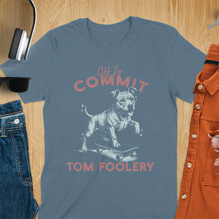 Indigo blue t-shirt featuring a pitbull riding a skateboard with text Off To Commit Tom Foolery in vintage red lettering
