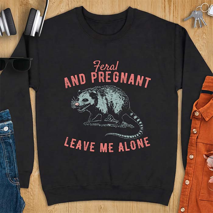 Black sweatshirt with a graphic of a hissing opossum baring its teeth with a striped tail, plus the text Feral And Pregnant Leave Me Alone.