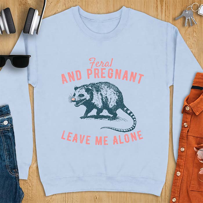 Light Blue sweatshirt with a graphic of a hissing opossum baring its teeth with a striped tail, plus the text Feral And Pregnant Leave Me Alone.
