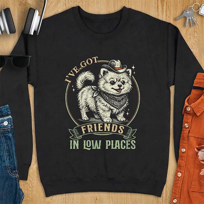 Black sweatshirt with a vintage western illustration of a fluffy Pomeranian wearing a cowboy hat and a paisley bandana, with the text I've Got arched above it and Friends In Low Places below it