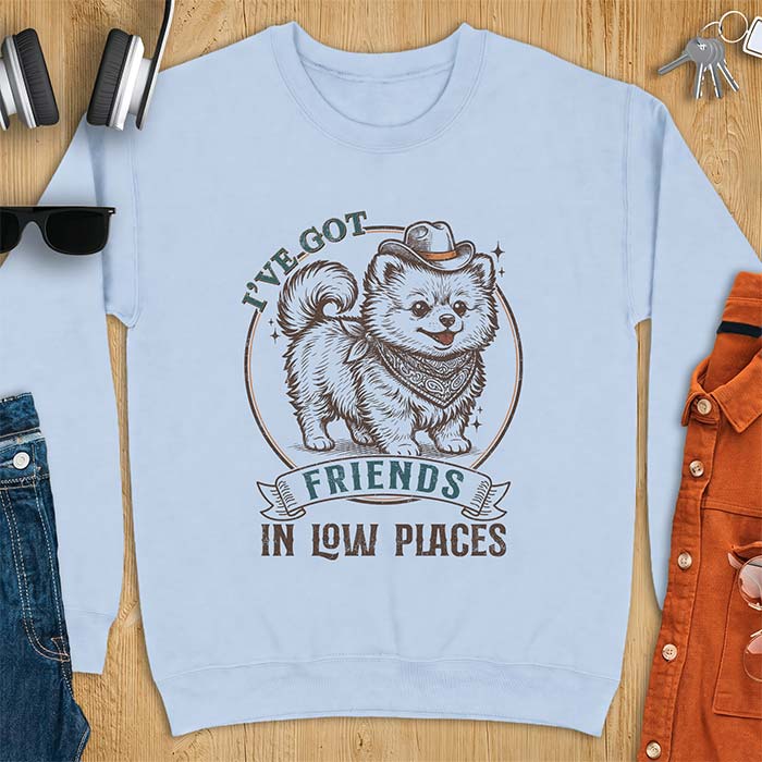 Light Blue sweatshirt with a vintage western illustration of a fluffy Pomeranian wearing a cowboy hat and a paisley bandana, with the text I've Got arched above it and Friends In Low Places below it