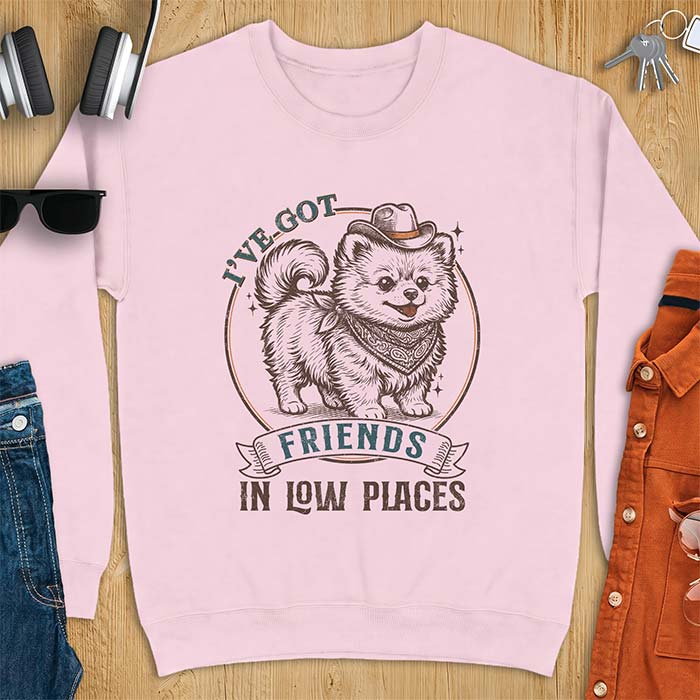 Light Pink sweatshirt with a vintage western illustration of a fluffy Pomeranian wearing a cowboy hat and a paisley bandana, with the text I've Got arched above it and Friends In Low Places below it