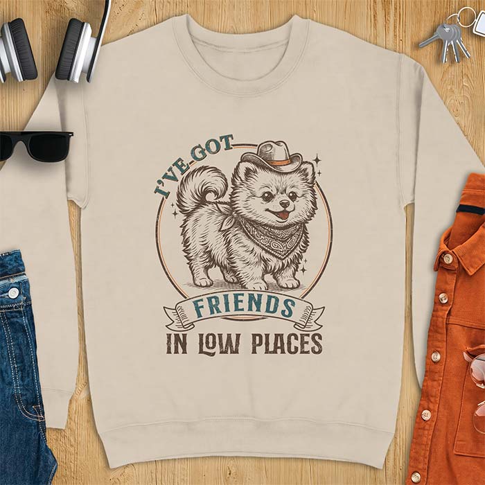 Sand sweatshirt with a vintage western illustration of a fluffy Pomeranian wearing a cowboy hat and a paisley bandana, with the text I've Got arched above it and Friends In Low Places below it