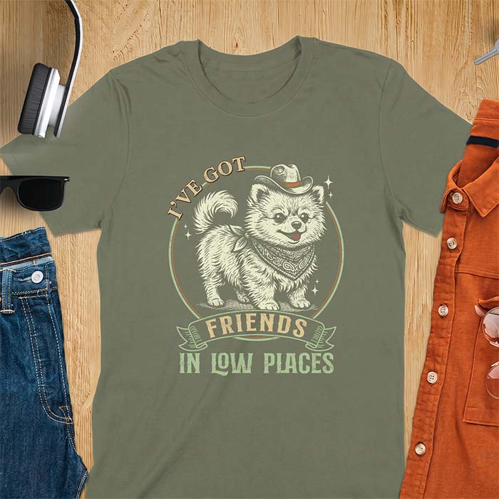Military Green t-shirt with a vintage western illustration of a fluffy Pomeranian wearing a cowboy hat and a paisley bandana, with the text I've Got arched above it and Friends In Low Places below it