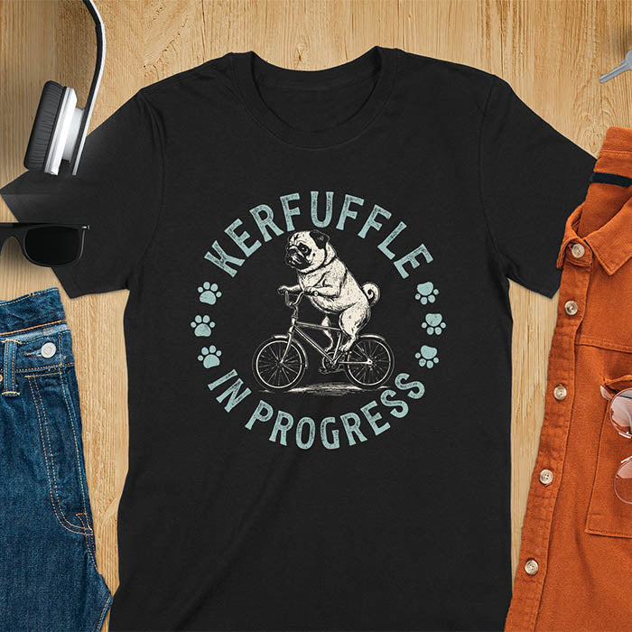 Pug on bicycle sketch-style graphic with Kerfuffle In Progress text and paw prints on black t-shirt