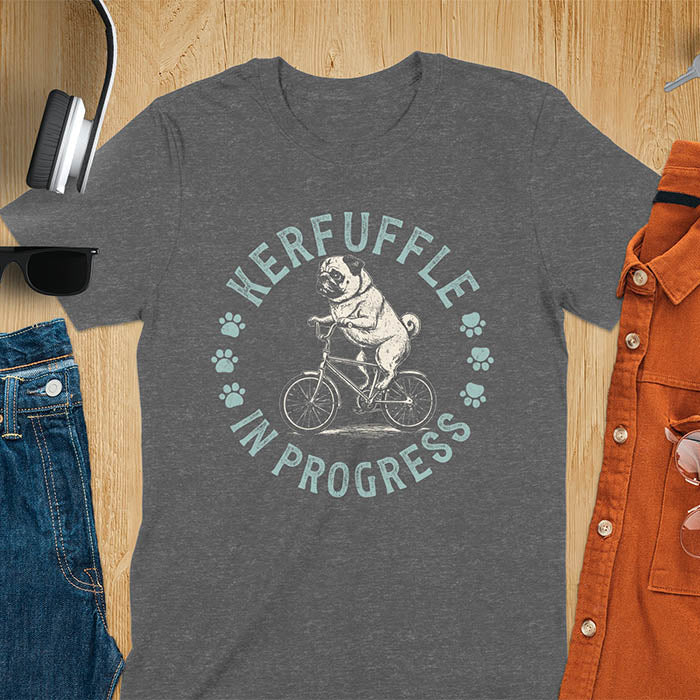 Pug on bicycle sketch-style graphic with Kerfuffle In Progress text and paw prints on dark heather t-shirt