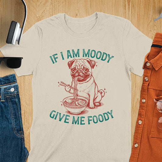 Sand color t-shirt with pug eating ramen with chopsticks graphic featuring 'If I Am Moody Give Me Foody' text - funny dog meme design