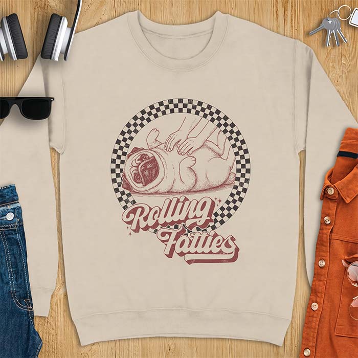 Sand sweatshirt with a graphic of a pug lying on its back inside a checkered circle while a pair of hands press into its rolled folds and the text Rolling Fatties