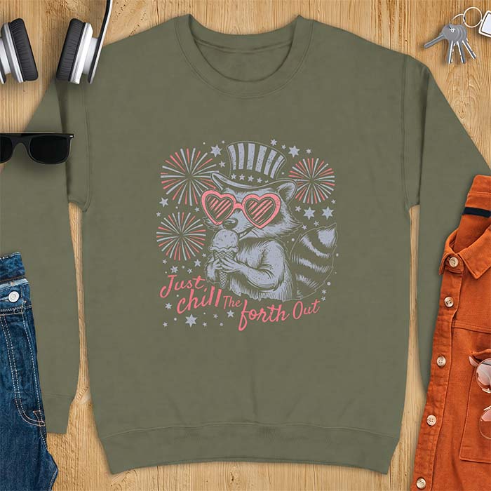 Military Green sweatshirt with a graphic of a raccoon in a striped top hat and heart-shaped sunglasses eating an ice cream cone in front of fireworks and stars, printed with the text Just Chill The Forth Out