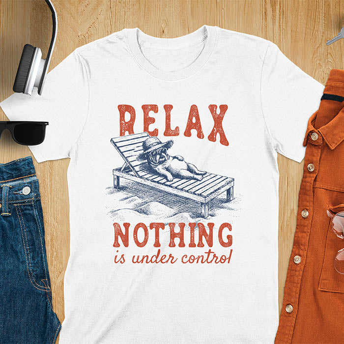 White t-shirt featuring a bulldog wearing a straw hat lounging on a beach chair with text Relax Nothing Is Under Control in vintage red lettering