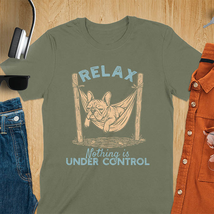 Military Green t-shirt with vintage-inspired illustration. Retro graphic features French bulldog relaxing in hammock with 'Relax' and 'Nothing is Under Control' text in distressed typography. Quirky zen humor meme design.