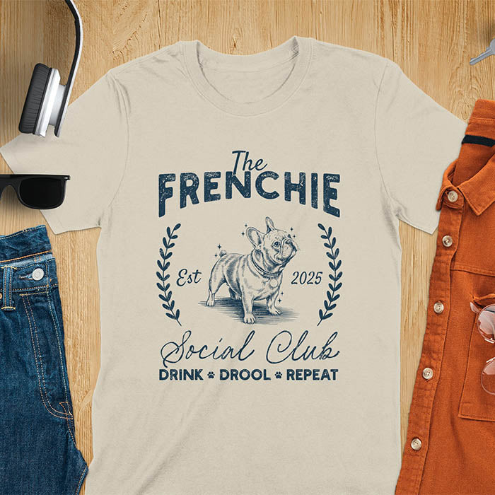 Sand color t-shirt with vintage French Bulldog graphic design featuring 'The FRENCHIE Social Club' text and Frenchie illustration.