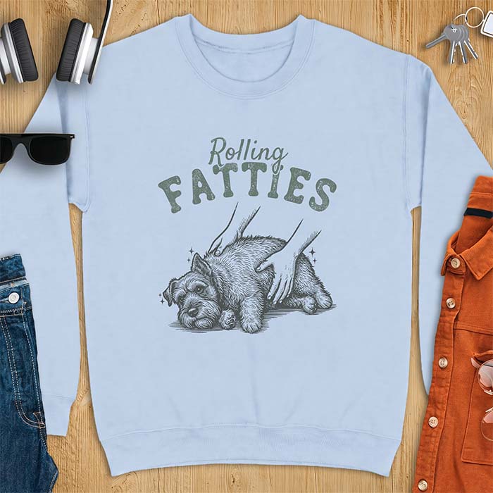 Light Blue sweatshirt with a graphic of a scruffy Schnauzer lying curled on the ground while two hands reach in to scratch and pet it, plus the text Rolling Fatties above.