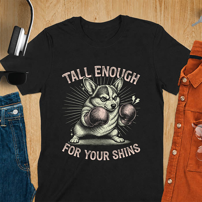Black graphic tee with retro illustration of a corgi wearing boxing gloves, text reads Tall Enough For Your Shins
