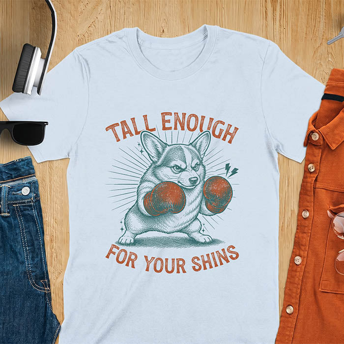 Light blue graphic tee with retro illustration of a corgi wearing boxing gloves, text reads Tall Enough For Your Shins