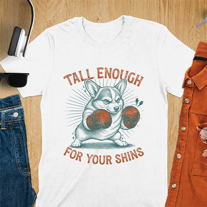 White graphic tee with retro illustration of a corgi wearing boxing gloves, text reads Tall Enough For Your Shins
