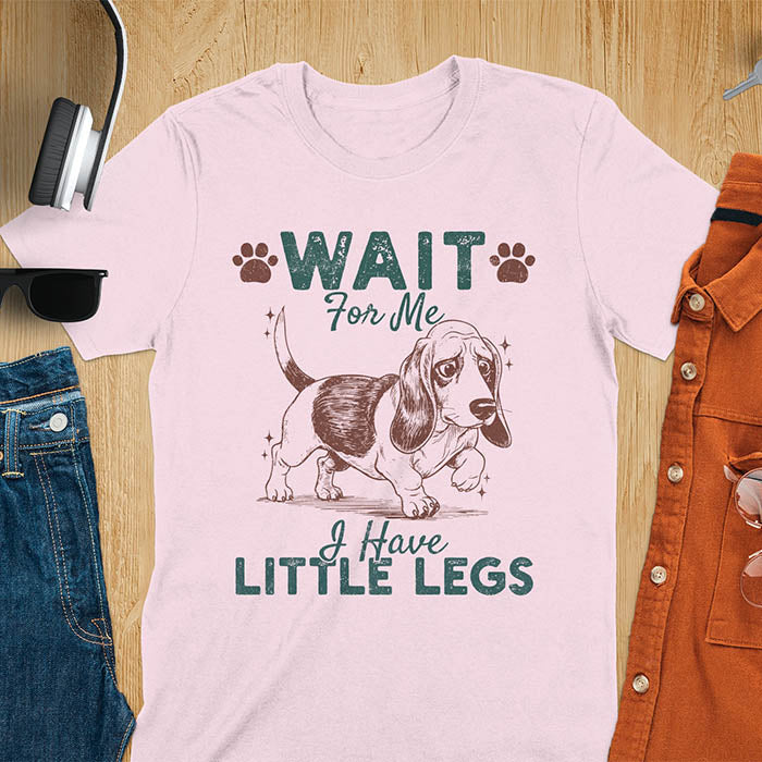 Basset hound meme t-shirt with dog illustration and text Wait For Me I Have Little Legs with paw prints - light pink