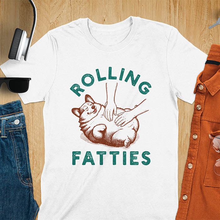 Chubby corgi illustration enjoying tummy rubs with Rolling Fatties text in textured lettering on white tee